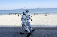 Бразилски пар обучен у астронаутска одијела шета градом и плажом